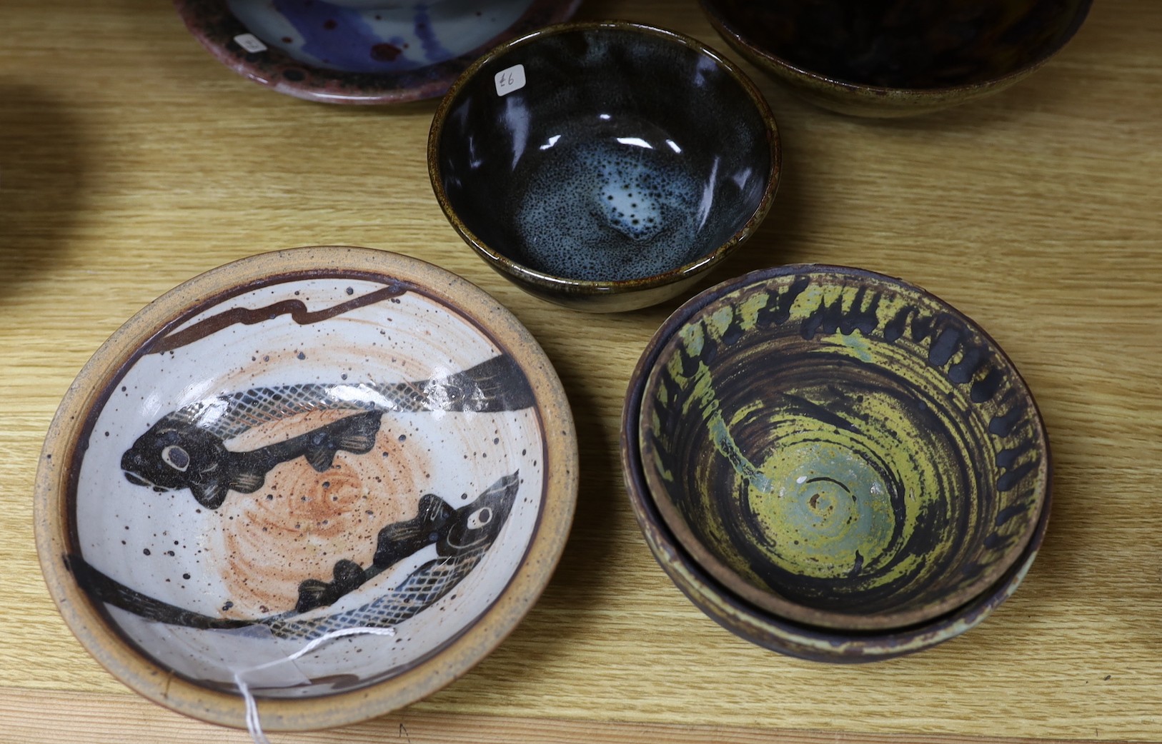 A large pottery figural tile together with a collection of studio pottery bowls